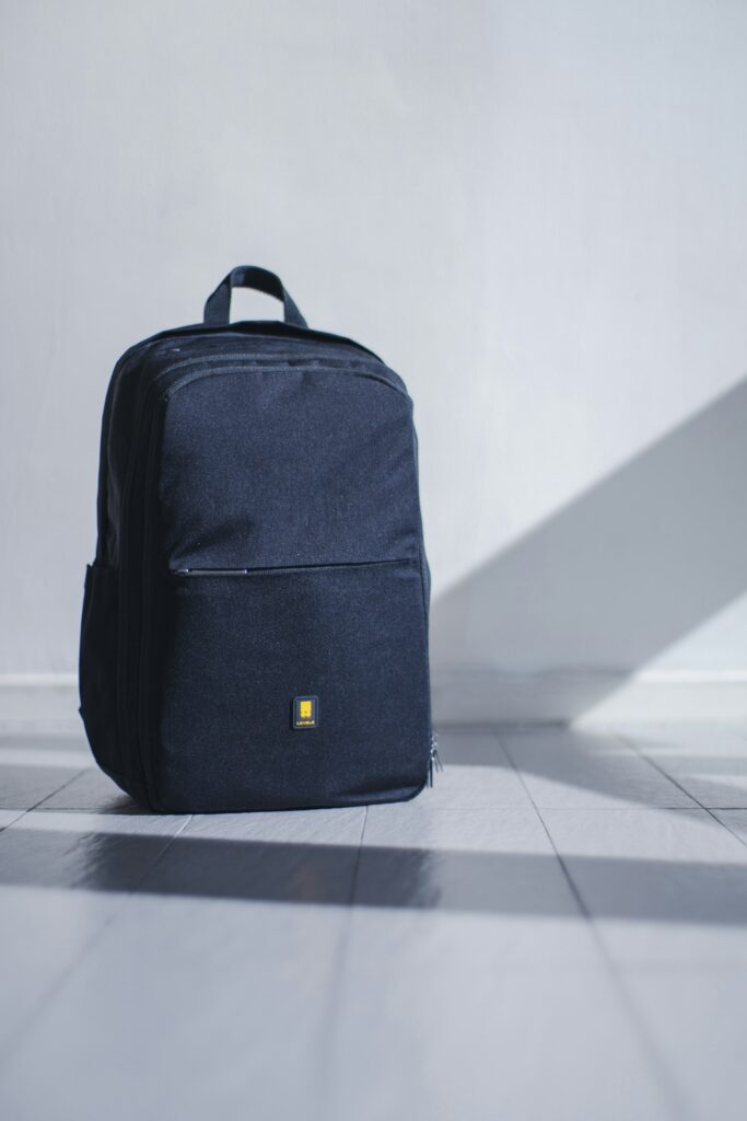 Black travel daypack on a light floor, ready for a Peru sightseeing day
