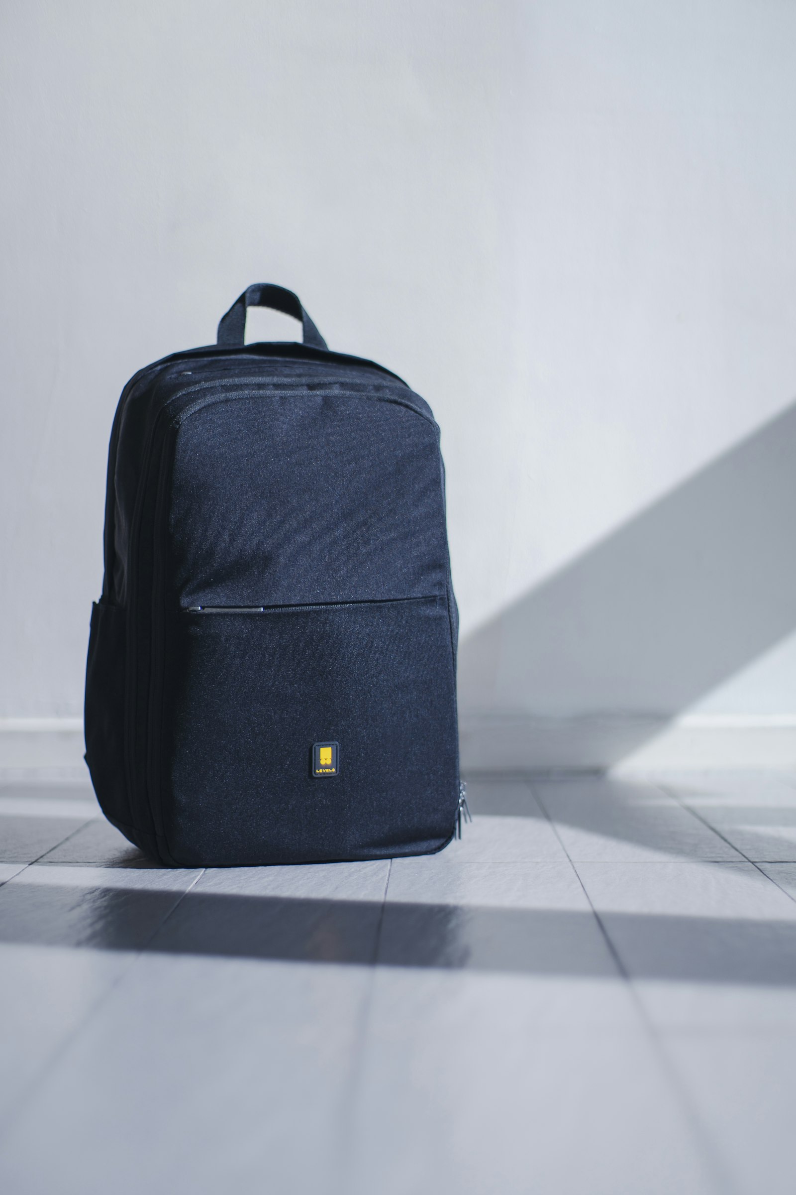 Black travel daypack on a light floor, ready for a Peru sightseeing day