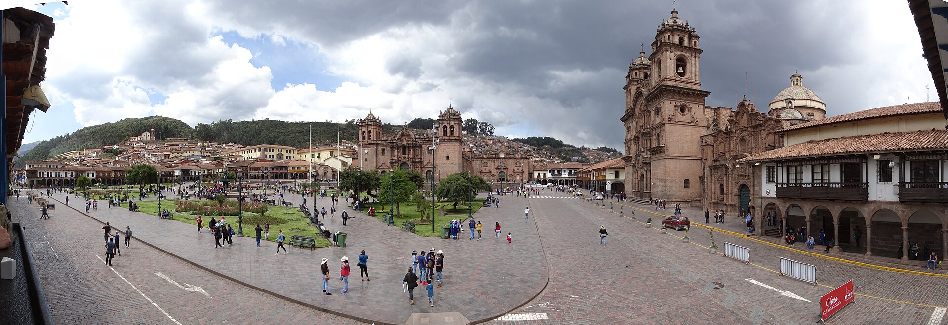 Travelers and locals around Cusco Plaza de Armas in a busy, well-lit tourist square