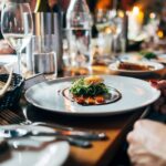 Restaurant table setting with plates and glassware suggesting dining and tipping in Peru